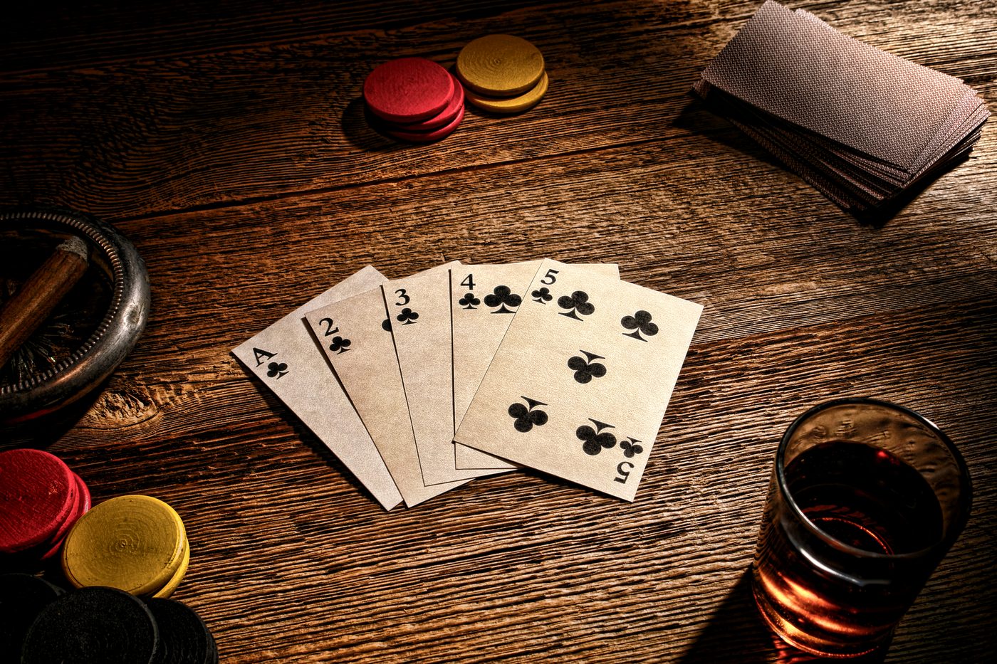 A classic hand of aces with chips and a cigar on a card table.