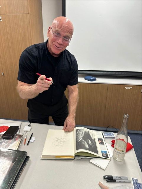 Michael Ammar signs a book for a member during his September 2024 visit