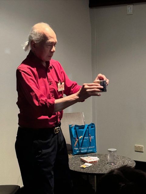 A member (name badge "Adam") performs a close-up effect