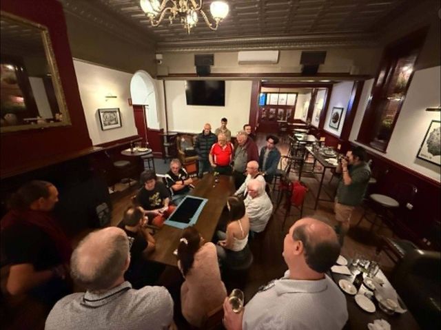 A packed table watching close-up magic in the Le Roi room, May 2026