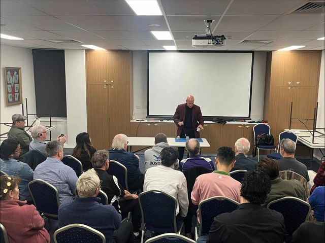 The lecturer performs cups-and-balls style magic for a full room at Freemasons WA, Subiaco