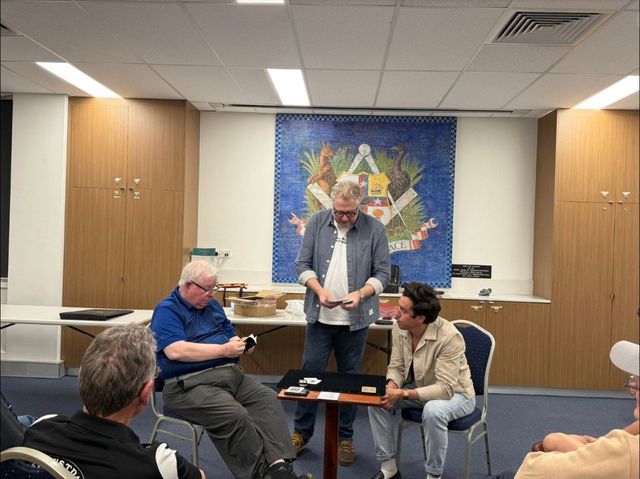 Chris Congreave performing for two seated volunteers during the lecture